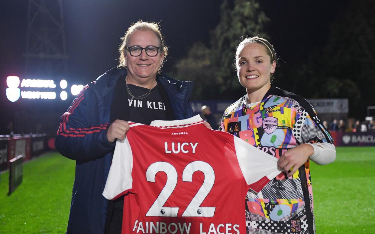 Lucy Clark is presented with a Rainbow Laces Arsenal home shirt by Gunners captain Kim Little before the Barclays FA Women's Super League match between Arsenal and West Ham United on October 30, 2022