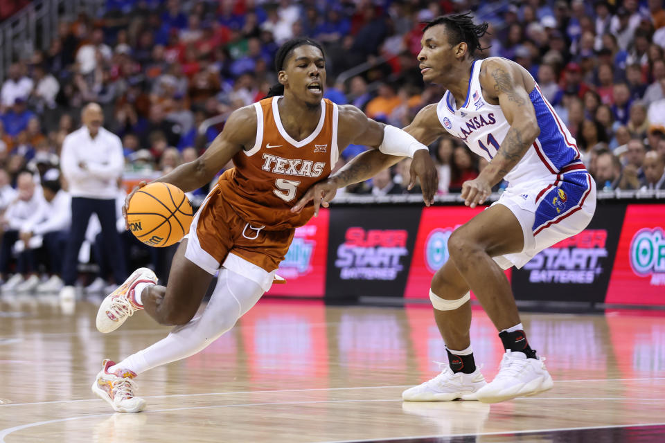 KANSAS CITY, MO - MARCH 11: Texas Longhorns guard Marcus Carr (5) drives against Kansas Jayhawks guard MJ Rice (11) in the second half of the Big 12 basketball tournament championship game between the Texas Longhorns and Kansas Jayhawks on March 11, 2023 at T-Mobile Center in Kansas City, MO. (Photo by Scott Winters/Icon Sportswire via Getty Images)