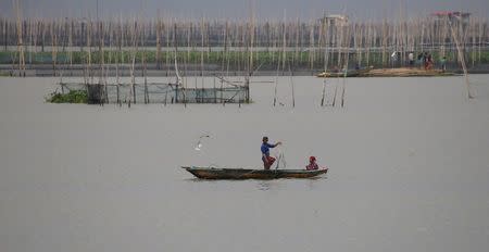 Residents fish in the calm waters of Laguna de bay in Muntinlupa, Metro Manila, Philippines December 15, 2015, amid heavy current and winds brought by Typhoon Melor in some parts of the country. REUTERS/Erik De Castro