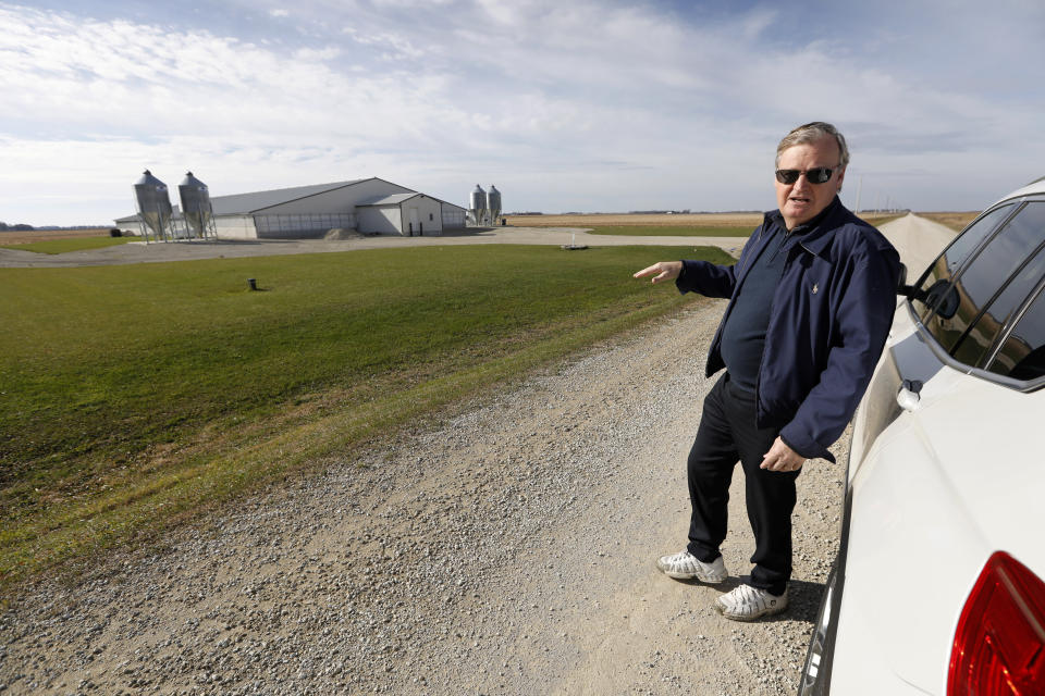 In this Oct. 29, 2018, photo, Brad Trom looks over a concentrated animal feeding operation, or CAFO, near his farm in Blooming Prairie, Minn. Critics say yesteryear's barnyard whiffs were nothing like the overpowering stench from today's supersized operations. "You don't want to be anywhere near them," said Trom, a fourth-generation crop farmer, who lives within three miles of 11 structures housing 30,000 swine. (AP Photo/Charlie Neibergall)