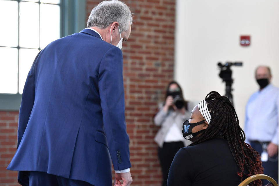 Louisville, Ky., Mayor Greg Fischer, left, speaks with Tamika Palmer, the mother of Breonna Taylor before the ceremonial signing of a bill creating a partial ban on no-knock warrants at the Center for African American Heritage in Louisville, Ky., Friday, April 9, 2021. (AP Photo/Timothy D. Easley)