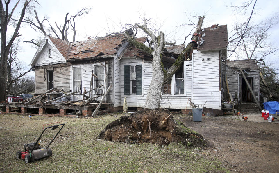 A house is damaged by an uprooted tree on Mabry St. in Selma, Ala., Friday, Jan. 13, 2023, after a tornado passed through the area. Rescuers raced Friday to find survivors in the aftermath of a tornado-spawning storm system that barreled across parts of Georgia and Alabama. (AP Photo/Stew Milne)
