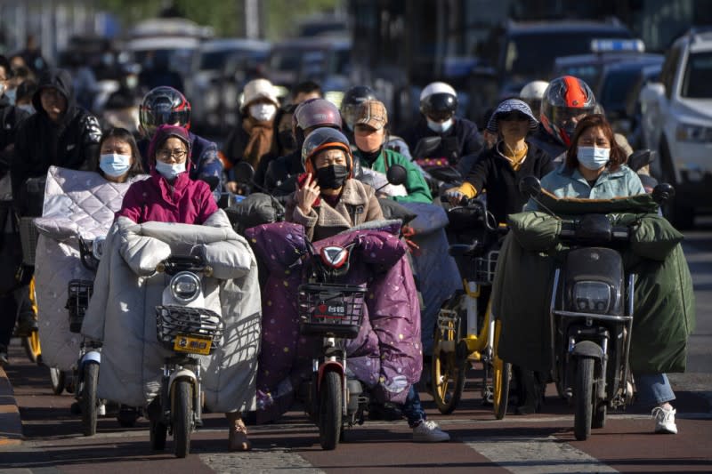 2022年4月，北京戴著口罩的機車騎士。（美聯社）