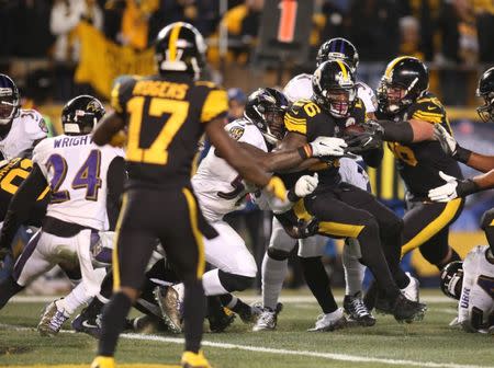 Dec 25, 2016; Pittsburgh, PA, USA; Pittsburgh Steelers running back Le'Veon Bell (26) backs into the end zone to score a seven yard touchdown against the Baltimore Ravens during the fourth quarter at Heinz Field. The Steelers won 31-27. Mandatory Credit: Charles LeClaire-USA TODAY Sports