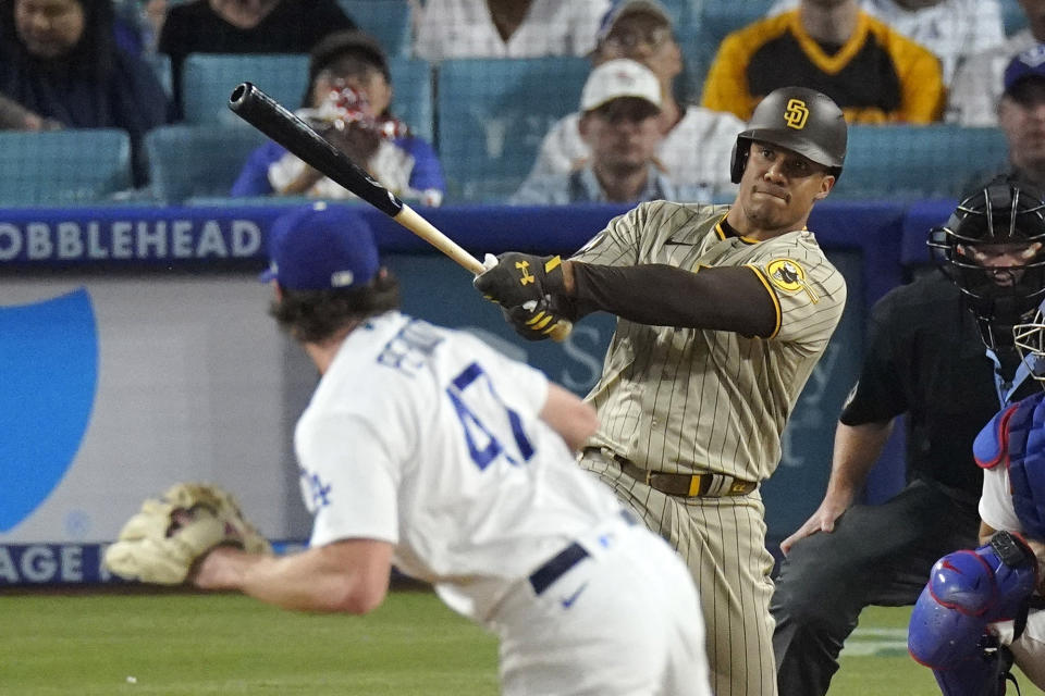 San Diego Padres' Juan Soto, center, hits a solo home run as Los Angeles Dodgers starting pitcher Ryan Pepiot watches during the first inning of a baseball game Wednesday, Sept. 13, 2023, in Los Angeles. (AP Photo/Mark J. Terrill)