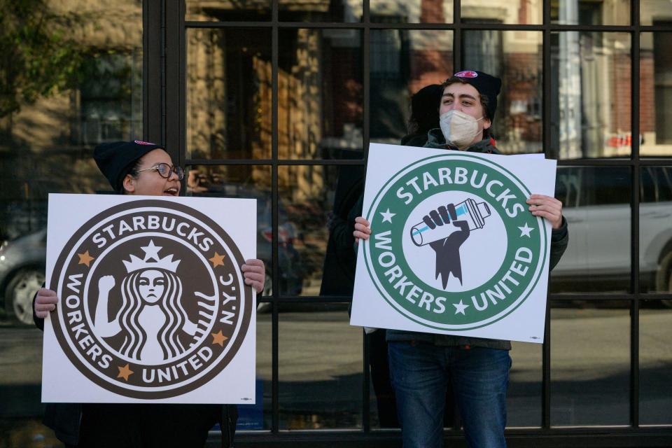 Starbucks workers on strike with signs that say "Starbucks Workers United"