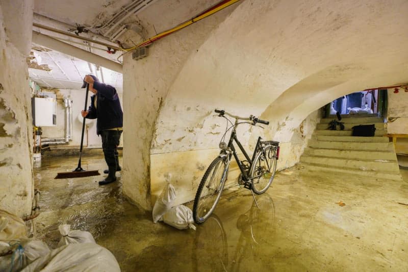 A resident pushes the water in his basement to the pumping point.  Andreas Arnold/dpa