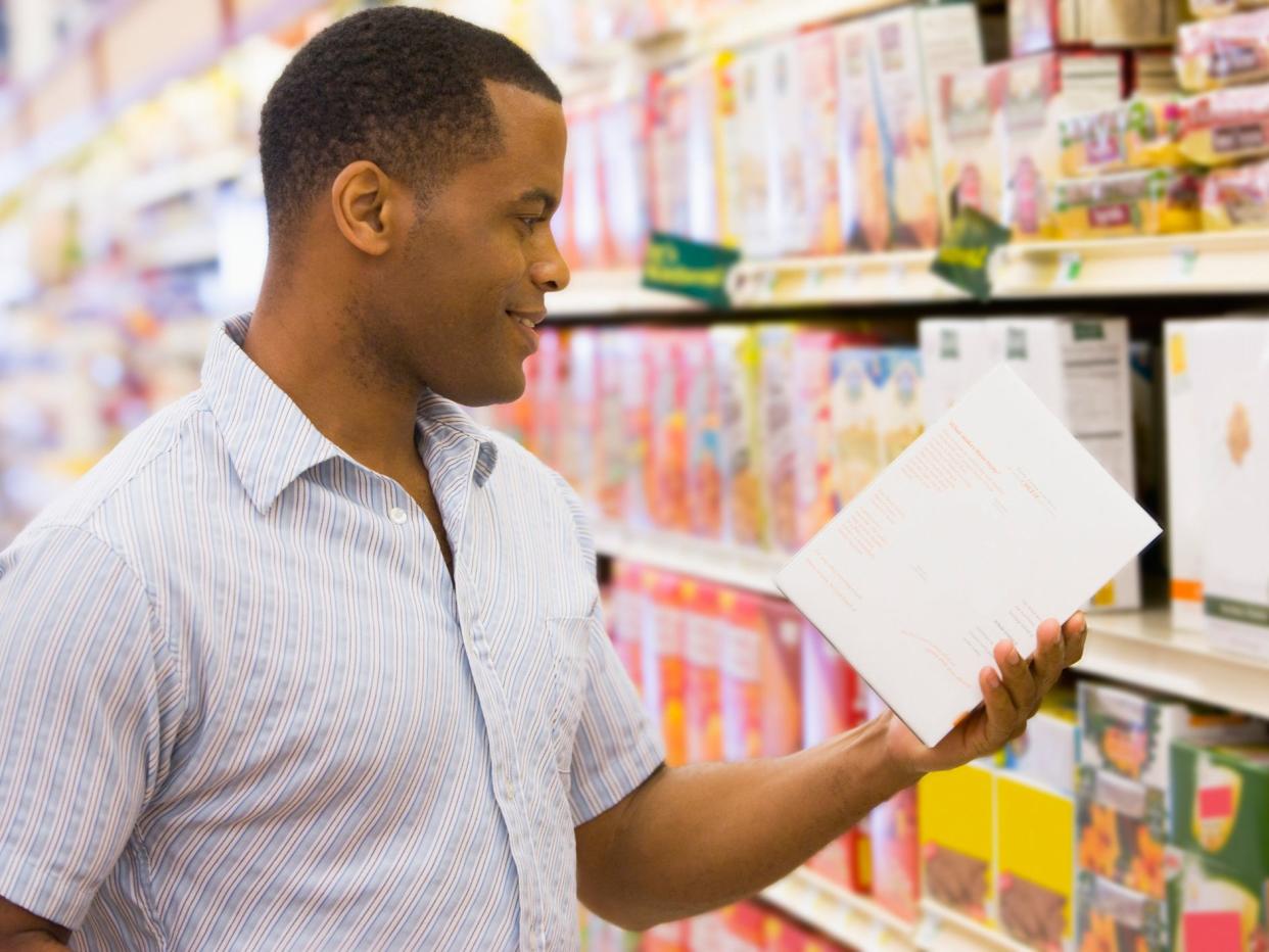 Man reading nutrition label on box 