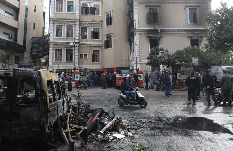 People gather at the municipality building that was set ablaze overnight, in the aftermath of protests against the lockdown and worsening economic conditions, amid the spread of the coronavirus disease (COVID-19), in Tripoli