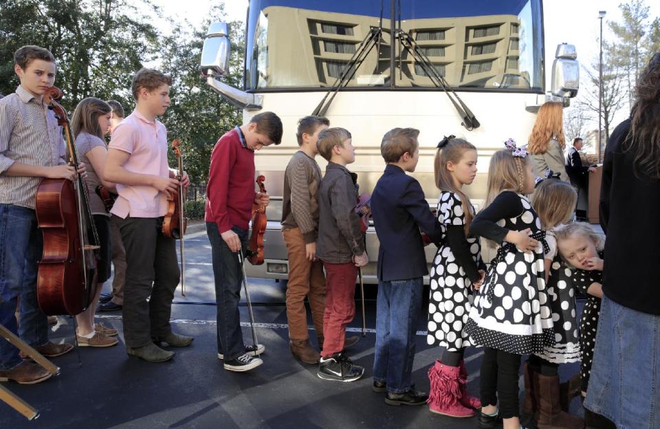 FILE - In this March 14, 2014 file photo, several of the Duggar family's 19 children wait to perform at a campaign event for Rev. Mark Harris, who is seeking a Republican U.S. Senate nomination in the upcoming North Carolina primary, in Raleigh, N.C., The Duggar family stars in a reality TV show. The kids' parents, Jim Bob and Michelle Duggar, were also on hand to support Harris. (AP Photo/Ted Richardson)