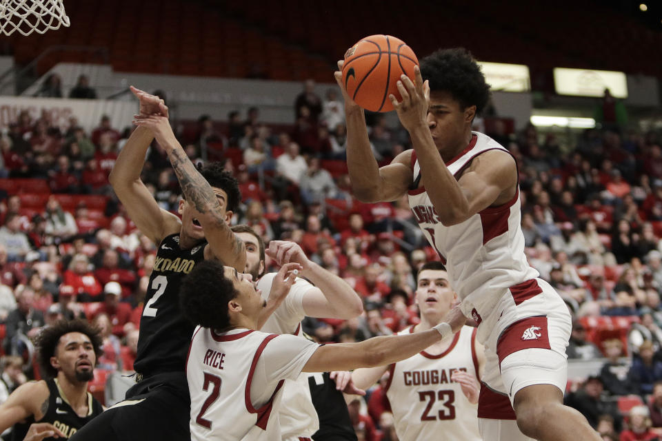 Washington State forward Jaylen Wells, right, grabs a rebound next to teammate Myles Rice, center, and Colorado guard KJ Simpson during the second half of an NCAA college basketball game, Saturday, Jan. 27, 2024, in Pullman, Wash. Washington State won 78-69. (AP Photo/Young Kwak)