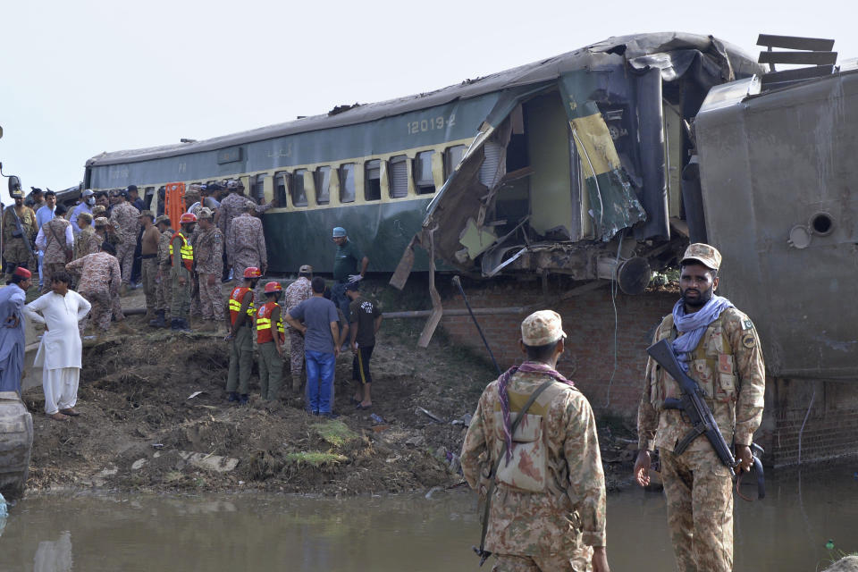 Rescue workers and army troops take part in a rescue operation at the site of a passenger train derailed near Nawabshah, Pakistan, Sunday, Aug. 6, 2023. Railway officials say some passengers were killed and dozens more injured when a train derailed near the town of Nawabshah in southern Sindh province. (AP Photo/Pervez Masih)