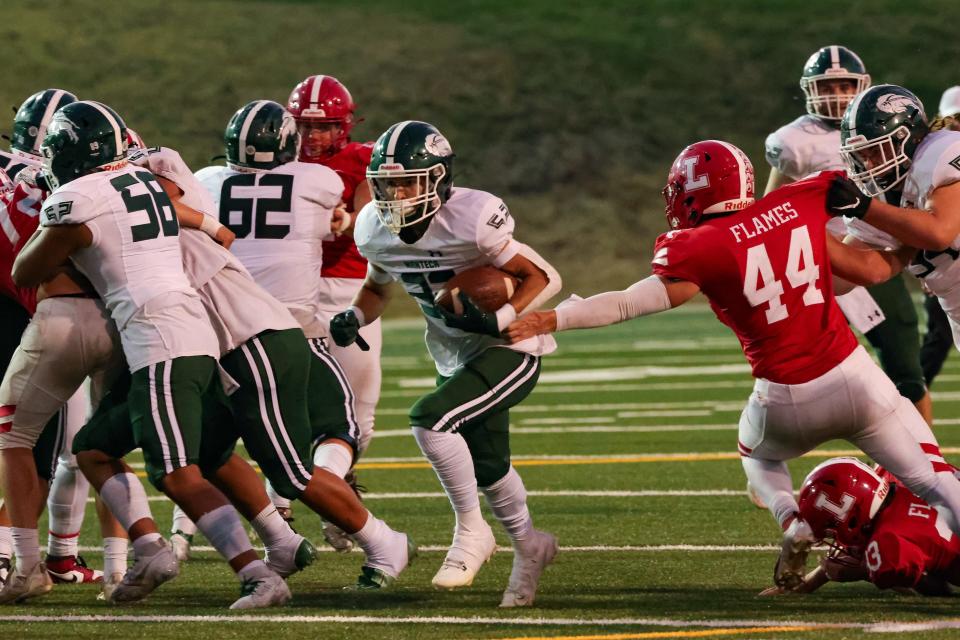 Manteca running back Nikko Juarez bursts through a huge hole created by the Manteca offensive line during a game between Manteca High School and Lodi High at The Grape Bowl in Lodi.