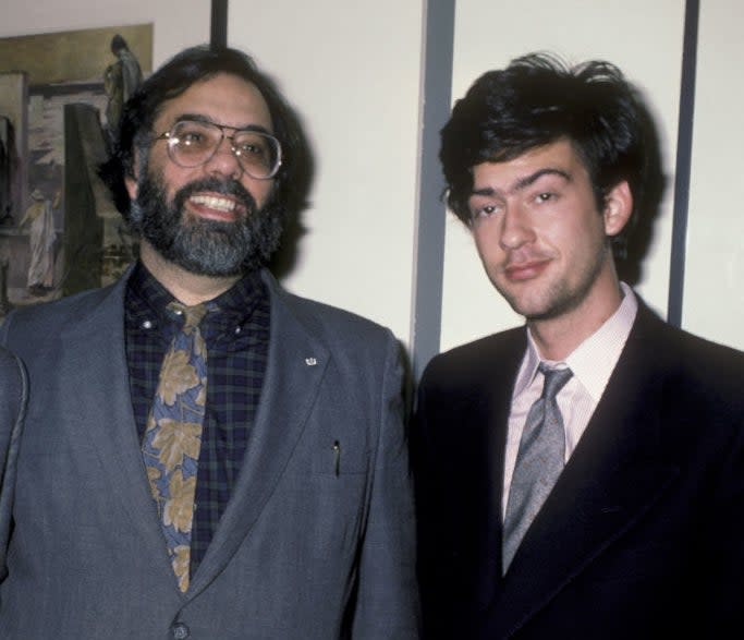 Francis and Gian-Carlo posing on a red carpet in suits