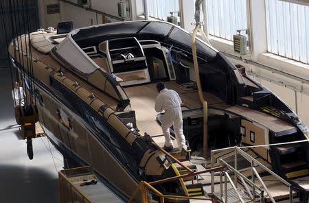 Employees work on a yacht at the Ferretti's shipyard in Sarnico, northern Italy, April 7, 2015. REUTERS/Stefano Rellandini