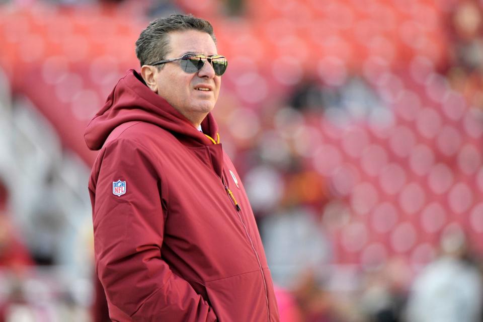 Dan Snyder stands on the field before a game between Washington and the Dallas Cowboys.