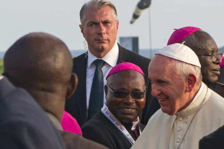 Pope Francis (R) meets with dignitaries, after being greeted by Uganda President Yoweri Museveni, upon his arrival on November 27, 2015 in Entebbe