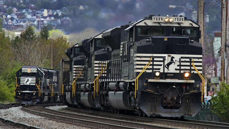 FILE - A Norfolk Southern freight train passes a train on a siding as it approaches a crossing in Homestead, Pa, Wednesday, April 27, 2022. Norfolk Southern's CEO Alan Shaw pledged to continue working to improve safety after Consultant the railroad hired following the fiery Ohio derailment recommended making sure that safety is truly a priority at all levels and continuing many efforts it has already begun. (AP Photo/Gene J. Puskar, File)