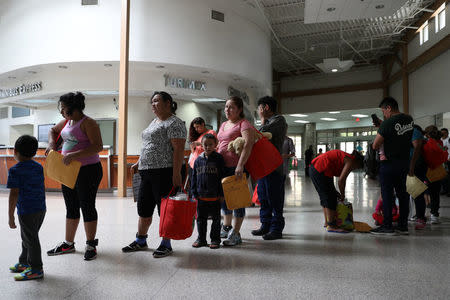 Undocumented immigrants recently released from detention prepare to depart a bus depot for cities around the country in McAllen, Texas, U.S., July 18, 2018. Picture taken July 18, 2018. REUTERS/Loren Elliott