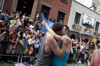 NEW YORK - JUNE 24: Revelers kiss in front of the Stonewall Inn during the New York City Gay Pride March on June 24, 2012 in New York City. The annual civil rights demonstration commemorates the Stonewall riots of 1969, which erupted after a police raid on a gay bar, the Stonewall Inn on Christopher Street. (Photo by Michael Nagle/Getty Images)