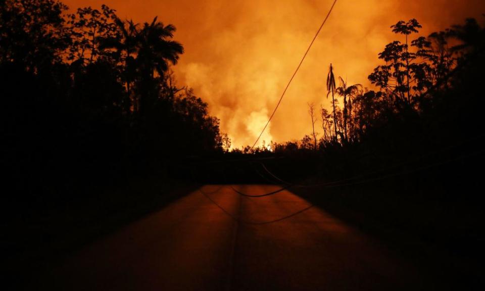 Lava from a Kilauea volcano fissure blocks a roadway and illuminates the night sky in Leilani Estates, on Hawaii’s Big Island, on 25 May 2018 in Pahoa, Hawaii. 
