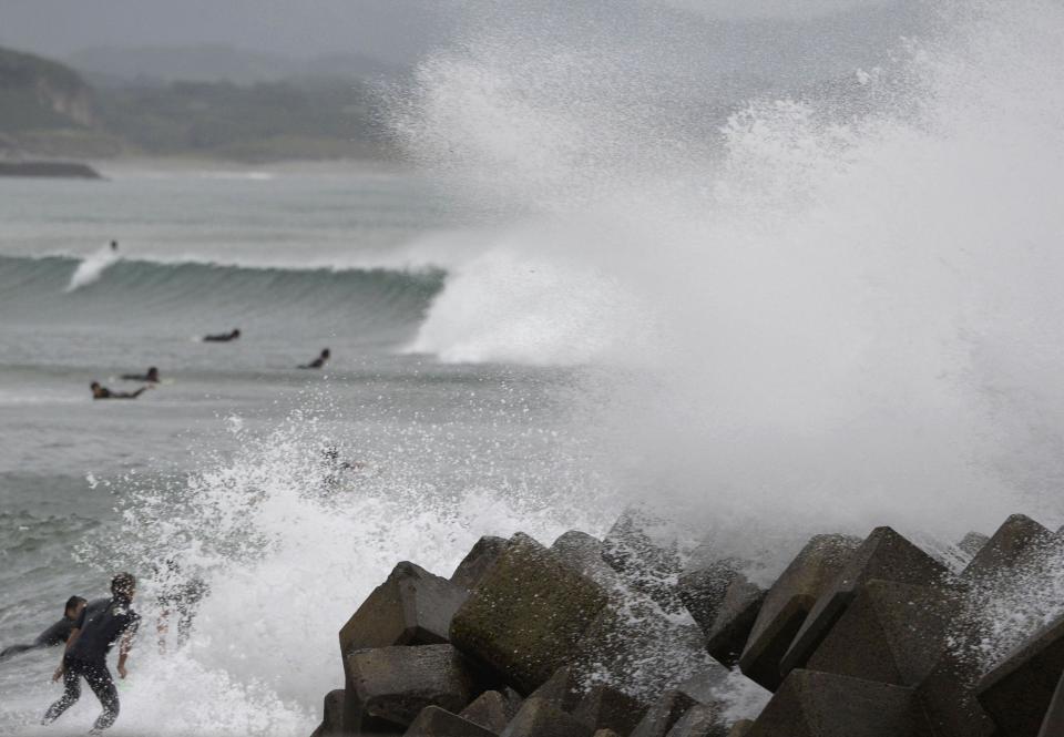 Waves crash as Typhoon Vongfong approaches Japan's main islands while surfers try to ride a wave at Eguchihama Beach in Hioki, Kagoshima prefecture, in this photo taken by Kyodo October 12, 2014. Typhoon Vongfong battered the southern Japanese island of Okinawa on Sunday, injuring 31 people and knocking out power before losing intensity and getting downgraded to a tropical storm. (REUTERS/Kyodo)