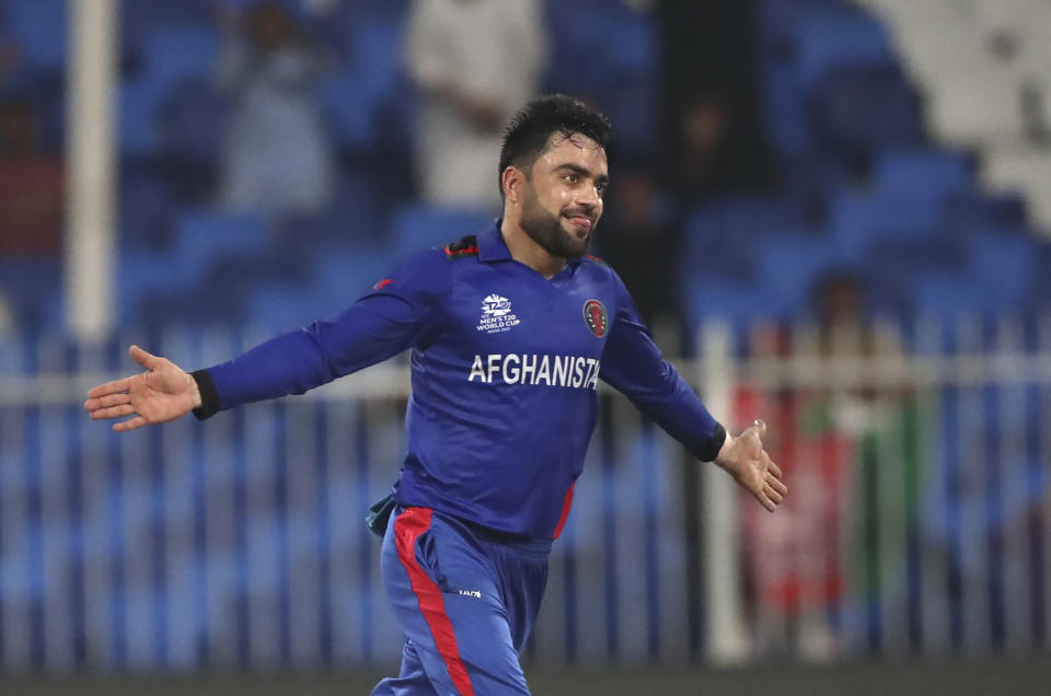 Afghanistan's Rashid Khan celebrates the wicket of Scotland's Brad Wheal, during the Cricket Twenty20 World Cup match between Afghanistan and Scotland in Sharjah, UAE, Monday, Oct. 25, 2021. (AP Photo/Aijaz Rahi)