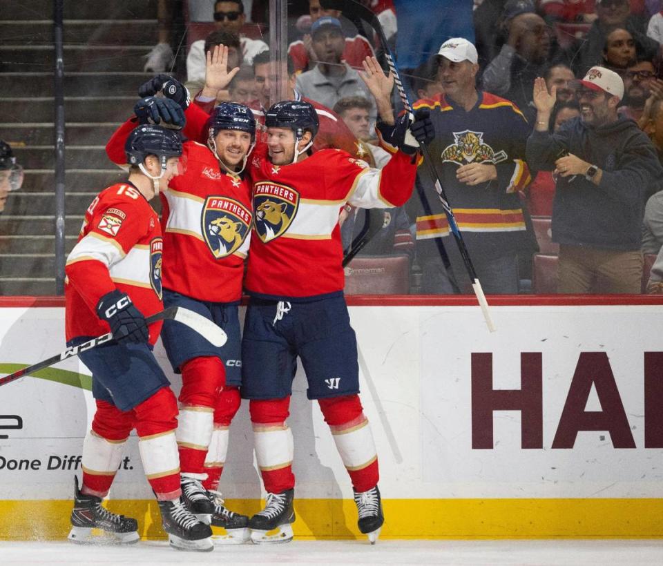Florida Panthers center Sam Reinhart (13) celebrates his goal with center Anton Lundell (15) and defenseman Dmitry Kulikov (7) during the second period of a hockey game on Wednesday, Jan. 17, 2024, at Amerant Bank Arena in Sunrise, Fla.