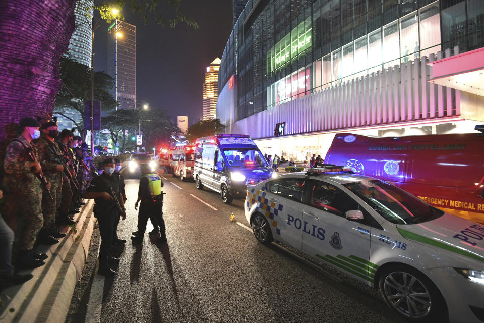 Fire and rescue personnel gather outside a shopping mall to help injured passengers at KLCC station after two trains of Kuala Lumpur Light Rail Transit (LRT) collided in Kuala Lumpur, Malaysia, Monday, May 24, 2021. (AP Photo)