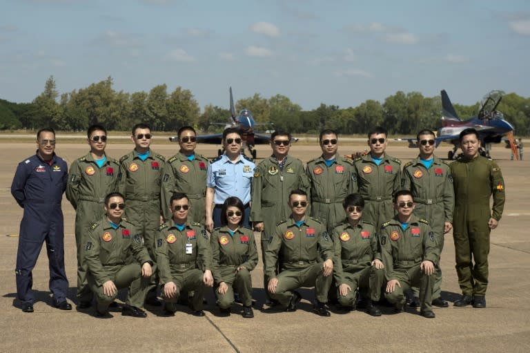 Thai Air Marshal Bhanupong Seyayongka (C,R), China's deputy chief of staff, Beijing regional Air Force Command Major General Feng Aiwang (C,L) surrounded by the People's Army Air Force pilots and two Royal Thai Air Force pilots (R & L) in Korat