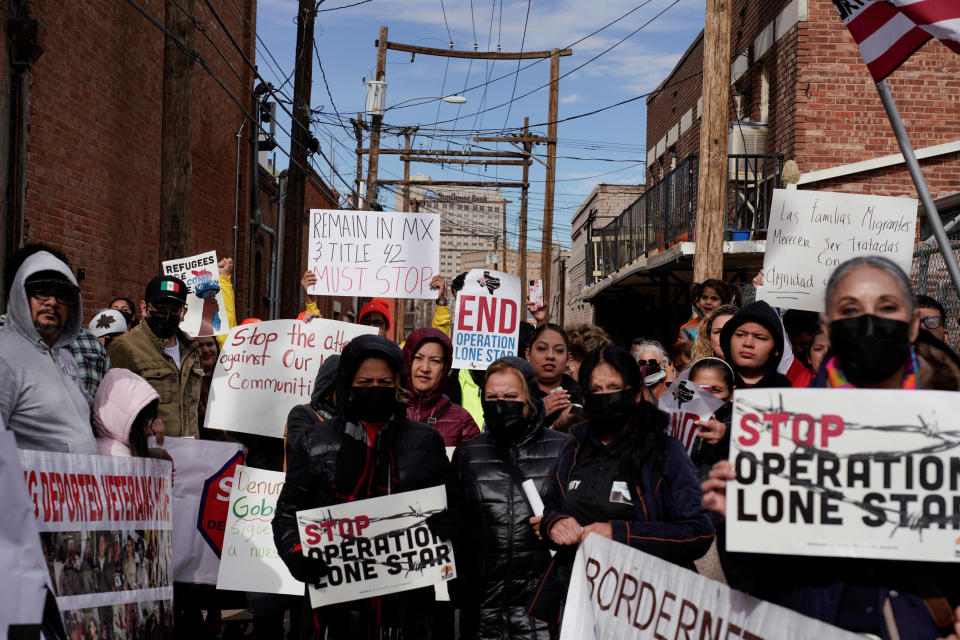 Protesters hold signs during a march to demand an end to the immigration policy known as Title 42..