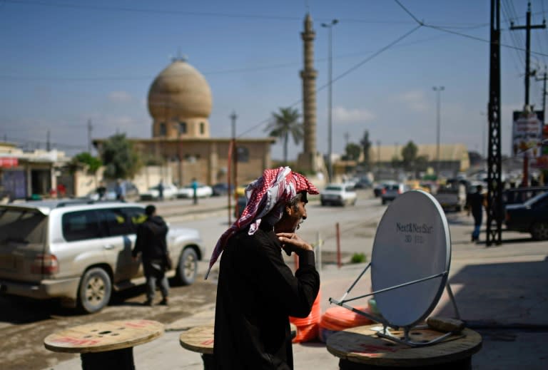 An Iraqi man inspects a satellite dish at a market in east Mosul on April 15, 2017. Since government forces recaptured the sector from the Islamic State group in January, residents have rushed to reconnect