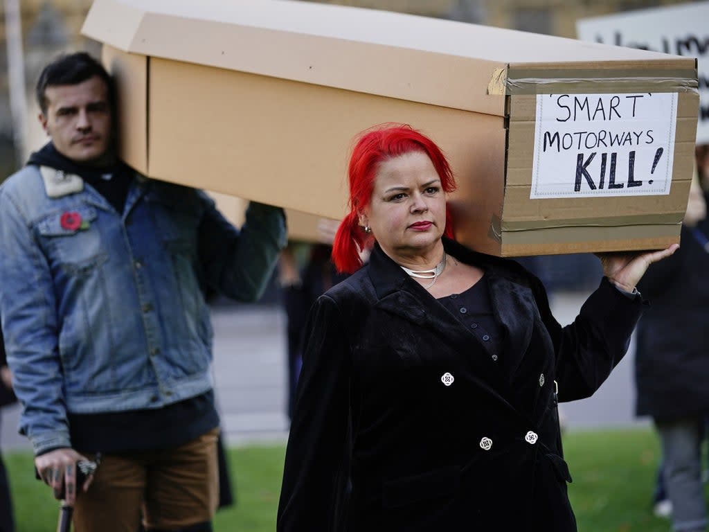 Demonstrators protesting against smart motorways march with coffins across Westminster Bridge to Parliament Square in London (PA)