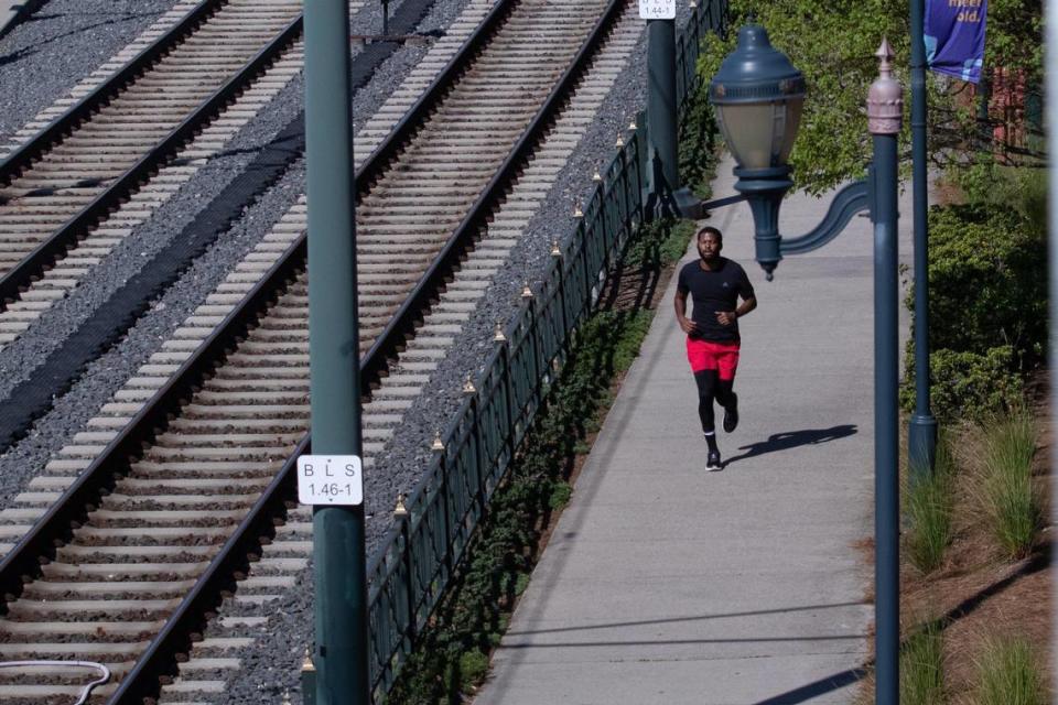 A man jogs on the path next to the light rail in South End on Thursday, April 3, 2020.