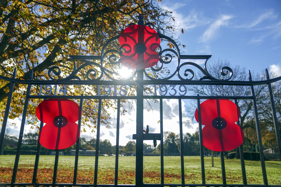 Poppies have been tied to the formal gates of the recreation ground playing fields in Chobham, Surrey. The ground was originally created as a war memorial following the First World War on meadowland purchased by money raised through a public appeal and as a further memorial after the Second World War, the formal gates and supporting wall were built and 32 chestnut trees were planted. People across the UK observed a two minute silence at 11 o'clock to remember the war dead. Picture date: Thursday November 11, 2021.