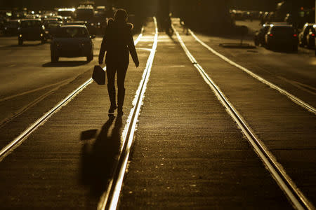 A woman crosses tram lines in the morning sun, in Bucharest, Romania, October 18, 2016. Inquam Photos/Octav Ganea/via REUTERS