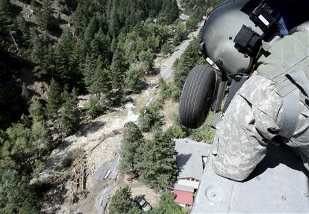 Staff Sergeant Jose Pantoja, with the 2-4 GSAB 4th Infantry Division based in Ft. Carson, looks from the open door of a Blackhawk helicopter for people in need of help near Jamestown, Colorado September 17, 2013. REUTERS/Mark Leffingwell