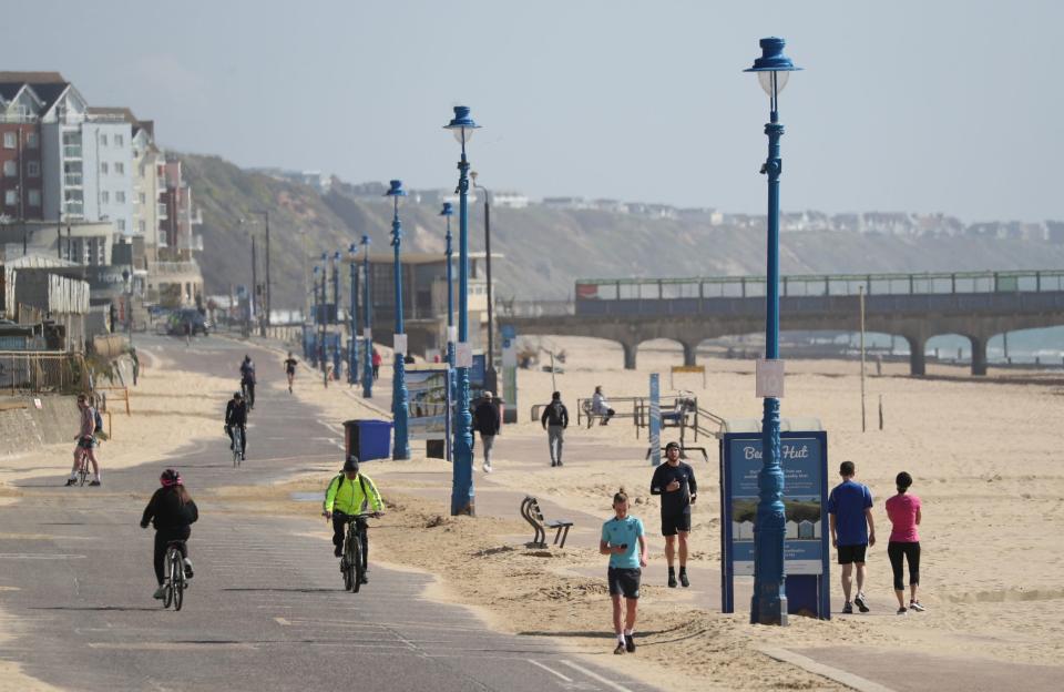 People exercise along the seafront on Boscombe beach during Saturday's sunshine (PA)