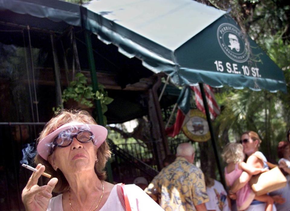 In 2003, Aida McVeigh has a cigarette as she and her family wait outside Perricone’s in downtown Miami before being seated.