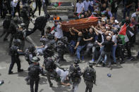 Israeli police confront with mourners as they carry the casket of slain Al Jazeera veteran journalist Shireen Abu Akleh during her funeral in east Jerusalem, Friday, May 13, 2022. Abu Akleh, a Palestinian-American reporter who covered the Mideast conflict for more than 25 years, was shot dead Wednesday during an Israeli military raid in the West Bank town of Jenin. (AP Photo/Maya Levin)