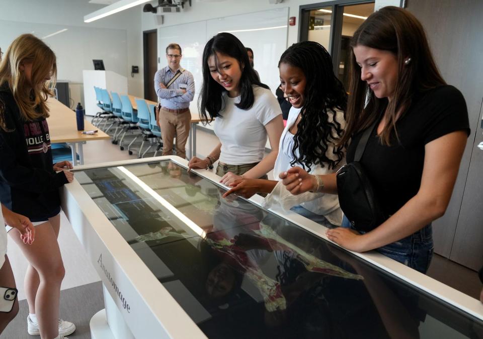 La Salle Academy students Anna Pan, Isabella Tettey and Emily Arruda explore the musculature, tendons and ligaments of a human being displayed on an Anatomage table, among the instructional tools at Providence College's new nursing school. The Anatomage table is a 3D human anatomy platform.