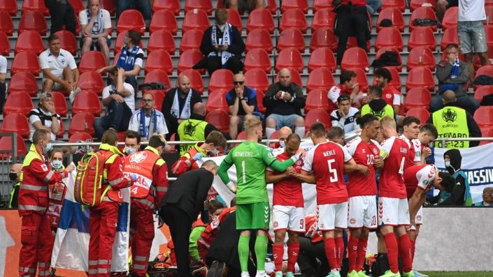 Denmark's teammates form a ring around the collapsed Christian Eriksen