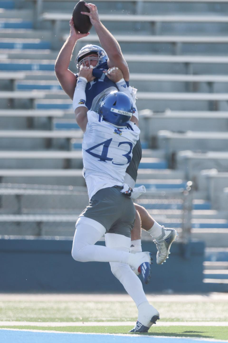 Kansas redshirt sophomore tight end Jared Casey (47) makes a catch over super-senior safety Andrew Russell (43) during a practice earlier this fall at David Booth Kansas Memorial Stadium
