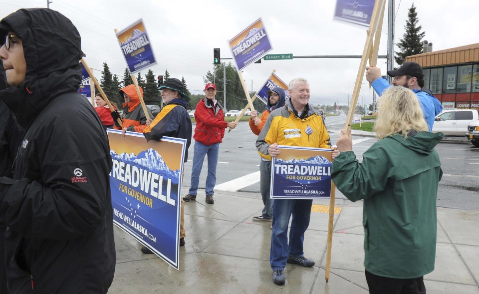 Republican gubernatorial candidate Mead Treadwell, in yellow, speaks with supporters while sign waving Tuesday August 21, 2018, in Anchorage, Alaska. Treadwell, a former Alaska lieutenant governor, is one of seven Republicans vying in the Alaska Primary. The winner advances to the general election and is expected to face incumbent Gov. Bill Walker, an independent, and former U.S. Sen. Mark Begich, a Democrat. (AP Photo/Michael Dinneen)