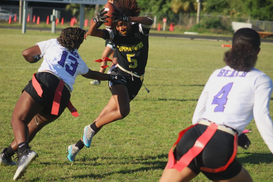 Ed White running back Tyra Pierce (5) sidesteps an attempted flag pull by Fletcher's Aviyanna Johnson (13) in the Gateway Conference girls flag football championship on April 4, 2024. [Clayton Freeman/Florida Times-Union]