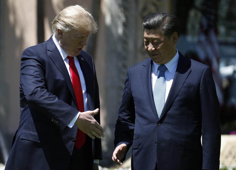 President Donald Trump and Chinese President Xi Jinping reach to shake hands at Mar-a-Lago, Friday, April 7, 2017, in Palm Beach, Fla. Trump was meeting again with his Chinese counterpart Friday, with U.S. missile strikes on Syria adding weight to his threat to act unilaterally against the nuclear weapons program of China's ally, North Korea. (AP Photo/Alex Brandon)