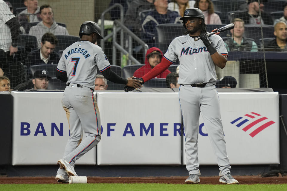 Miami Marlins' Tim Anderson, left, is greeted by Josh Bell after scoring on a hit by Nick Fortes during the ninth inning of the baseball game against the New York Yankees at Yankee Stadium, Wednesday, April 10, 2024, in New York. The Marlins defeated the Yankees 5-2. (AP Photo/Seth Wenig)