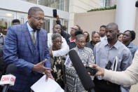 Civil co-counsel Malik Shabazz, left, speaks with reporters, accompanied by Eddie Terrell Parker and his aunt Linda Rawls, second from left, Mary Jenkins and her son Michael Corey Jenkins, outside the federal courthouse in Jackson, Miss., Thursday, March 21, 2024, following the sentencing of former Rankin County deputy Brett McAlpin to more than 27 years in federal prison for his role in the racially motivated, violent torture of Parker and Jenkins last year. McAlpin is the fifth of six former Mississippi Rankin County law enforcement officers to be sentenced in federal court since Tuesday. (AP Photo/Rogelio V. Solis)