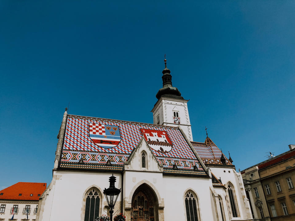 St. Mark's Church on a sunny afternoon in late summer. The church with its colorful roof tiles is in the center of the frame.