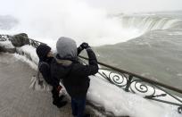 Visitors take pictures overlooking the falls in Niagara Falls, Ontario, January 8, 2014. The frigid air and "polar vortex" that affected about 240 million people in the United States and southern Canada will depart during the second half of this week, and a far-reaching January thaw will begin, according to AccuWeather.com. REUTERS/Aaron Harris (CANADA - Tags: ENVIRONMENT TRAVEL)
